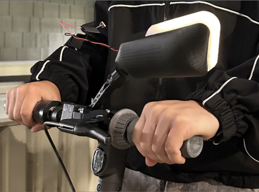 Rider's hands on the handlebar with the mirror and indicator light in use